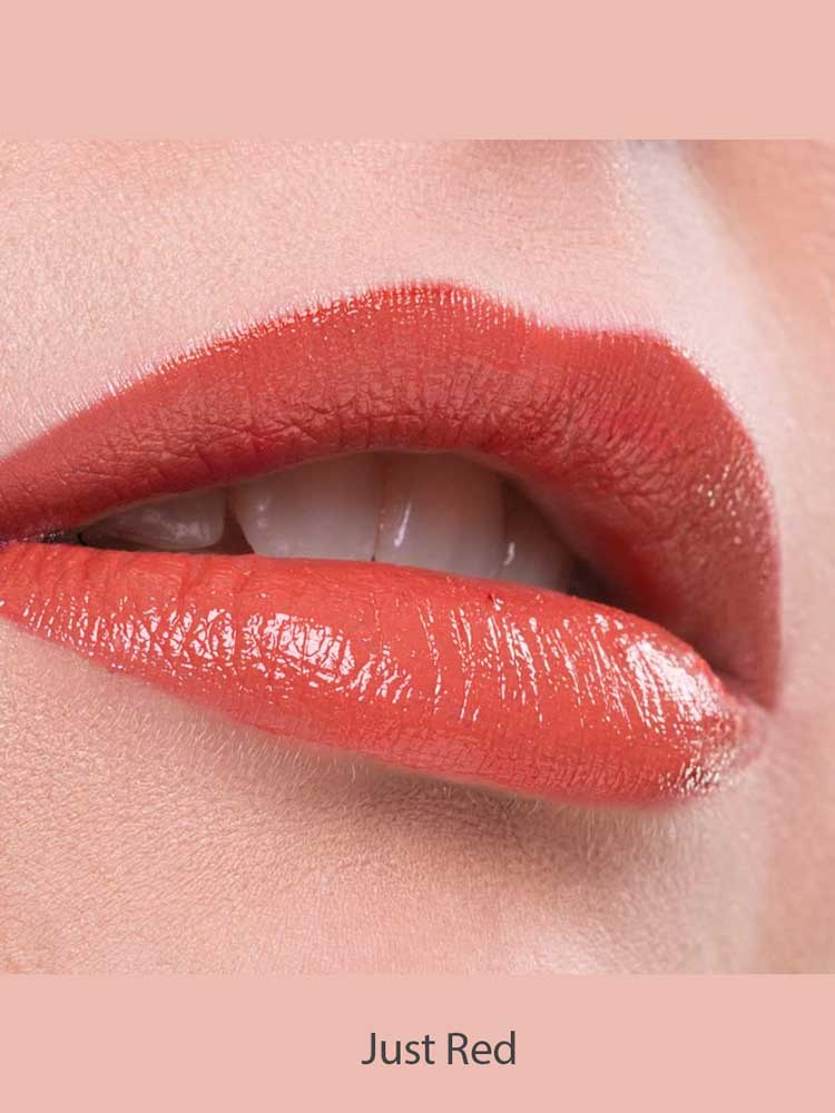 Close-up of lips wearing glossy red Benecos Natural Lipsticks 4.5g, slightly parted to reveal white teeth. "Just Red" appears below on a light pink background.