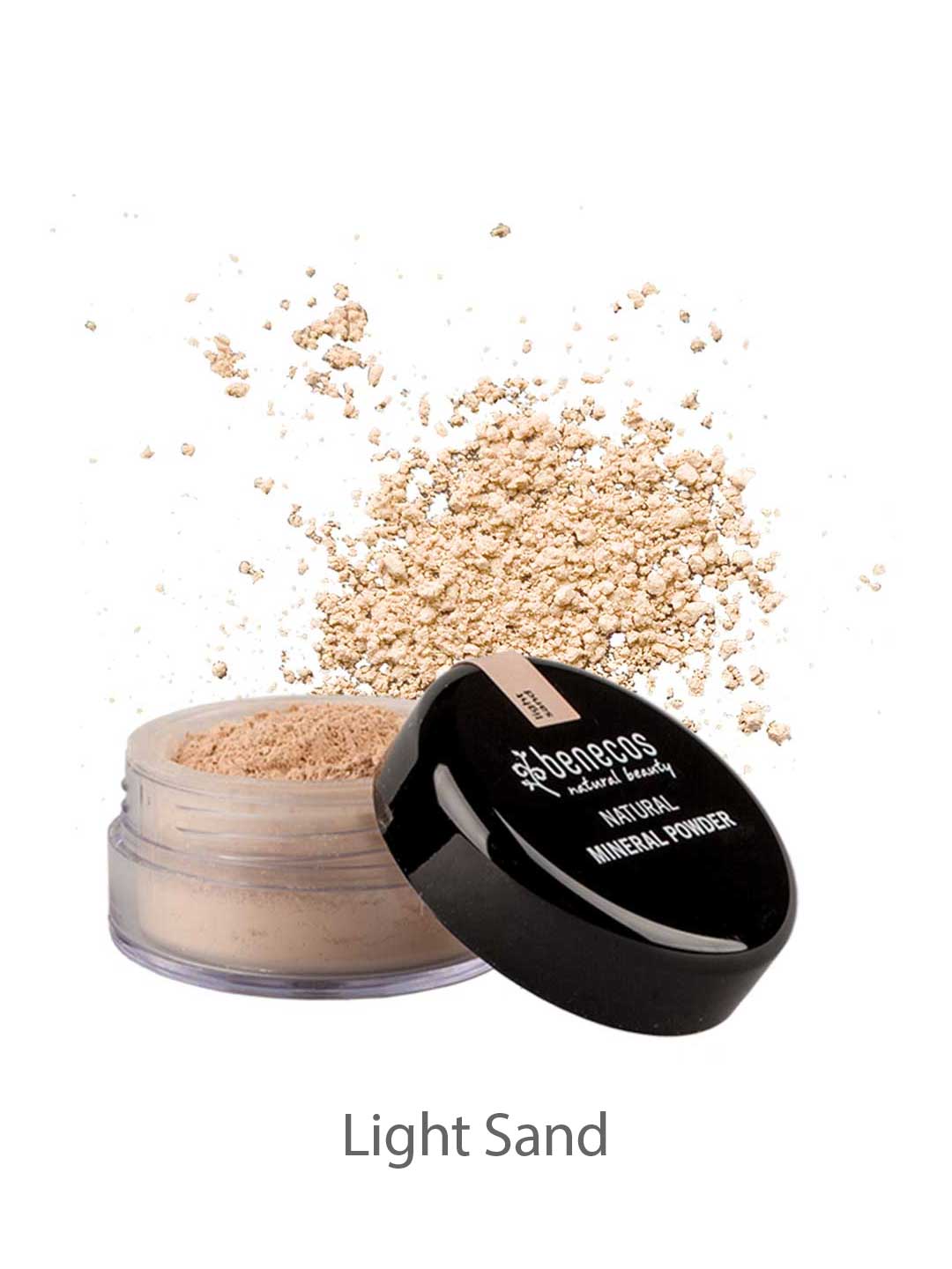 An open container of Benecos Natural Mineral Powder 10g, a light sand-colored talc-free loose powder, is shown with some powder scattered in the background. The black lid sits beside it, promising a natural matte finish.