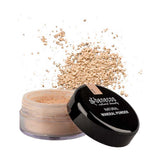 An open container of Benecos Natural Mineral Powder 10g in the shade Sand with a matte finish, loose powder scattered around it, and the black lid set aside.