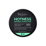 A 28g round black container labeled Black Chicken Remedies Hotness Natural Muscle Rub features arnica in a 100% natural warming balm to help relieve aches and pains, with directions to peel the label for more information.