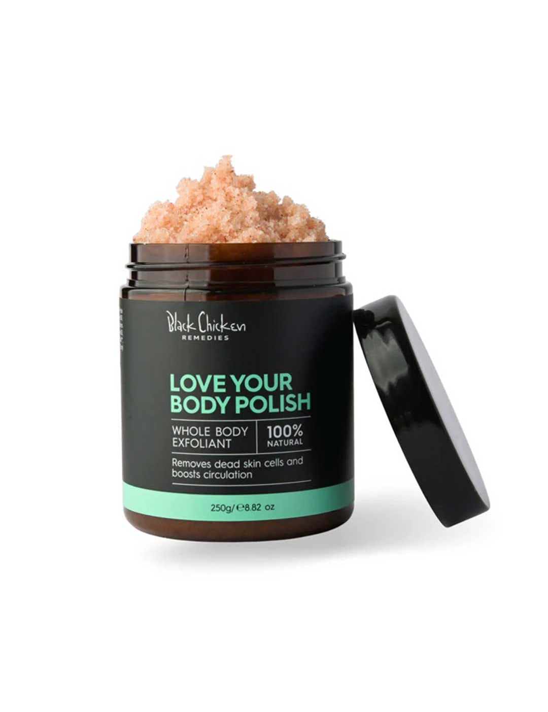A jar of Black Chicken Remedies Love Your Body Polish Natural Body Scrub 250g with the lid open reveals a pink, granular scrub made with Himalayan Pink Salt for gentle exfoliation; the label states it is 100% natural.
