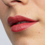 Close-up of lips with fair, freckled skin wearing Antipodes Moisture Boost Natural Lipsticks 4g in a warm bronze shade and satin finish. The text "Boom Rock Bronze" is displayed at the bottom.