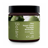 A jar of Botâni Olive Repair Cream Day/Night Moisturiser, featuring a dark olive green label with an image of green olives, a black lid, and a dark brown glass jar, set against a plain white background.