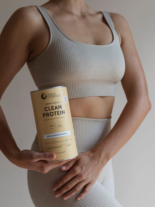 Woman holding Nutra Naturals Clean Plant Protein Creamy Vanilla