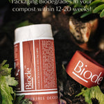 Terracotta Biode Into the Earth deodorant tube and detached cap among leaves and compost. Text states that the packaging biodegrades in compost within 12–20 weeks.