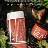 Terracotta Biode Into the Earth deodorant tube and detached cap among leaves and compost. Text states that the packaging biodegrades in compost within 12–20 weeks.