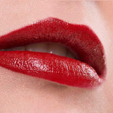 Close-up of glossy red lips wearing Benecos Natural Lipsticks 4.5g, highly pigmented and slightly parted to show a hint of teeth. The background and skin are neutral, with "Cat Walk" displayed at the bottom.