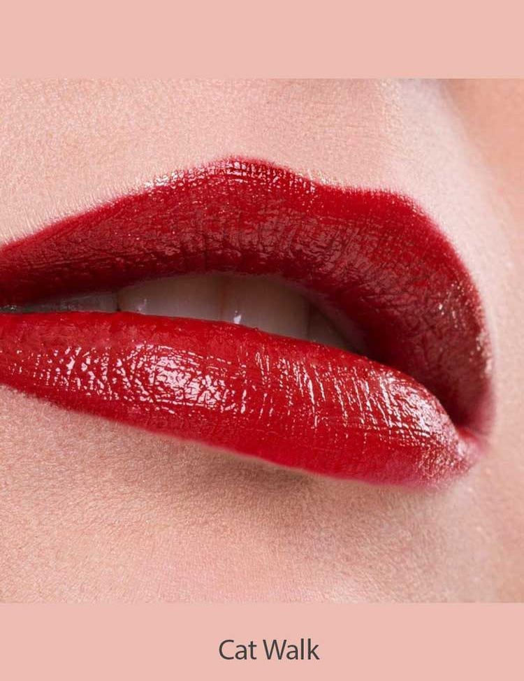 Close-up of glossy red lips wearing Benecos Natural Lipsticks 4.5g, highly pigmented and slightly parted to show a hint of teeth. The background and skin are neutral, with "Cat Walk" displayed at the bottom.