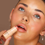 Model applying Avocado Zinc SPF50 Natural Lip & Cheek Tint in Coral directly to her lips.