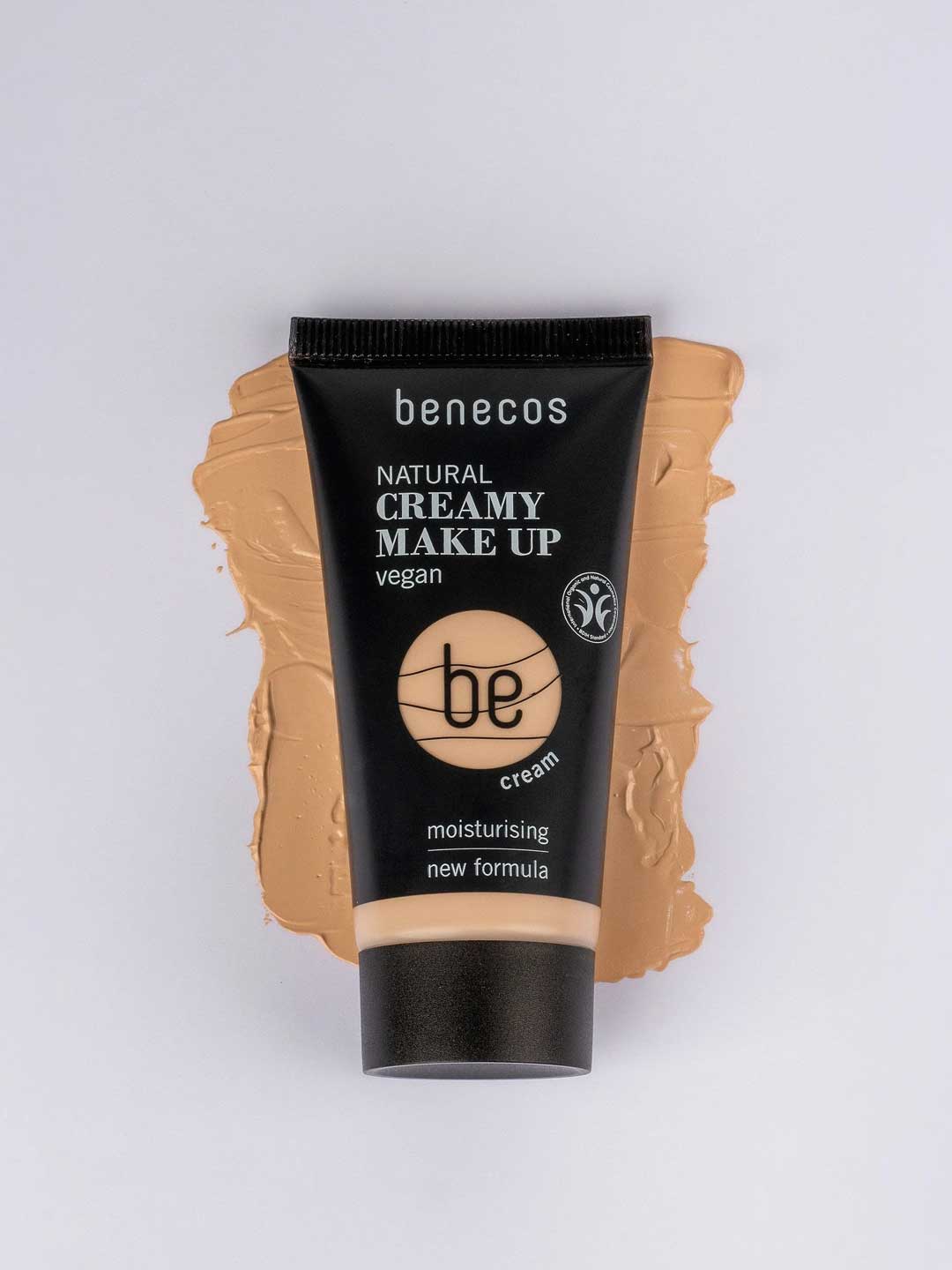A tube of Benecos Natural Creamy Makeup 30ml rests on a beige smear, showcasing its vegan formula and hydrating foundation benefits.