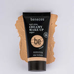 A tube of Benecos Natural Creamy Makeup 30ml rests on a beige smear, showcasing its vegan formula and hydrating foundation benefits.