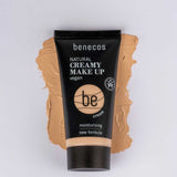 A tube of Benecos Natural Creamy Makeup 30ml rests on a beige smear, showcasing its vegan formula and hydrating foundation benefits.