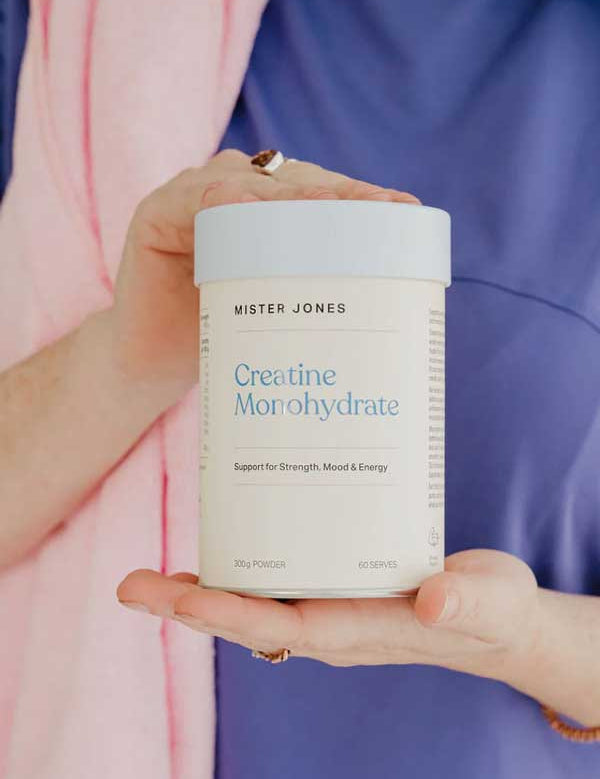 A person in a purple shirt holds a Mister Jones Creatine Monohydrate 300g container, showcasing this pure creatine supplement designed to support strength, mood, and energy.