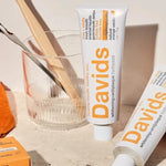 Davids Orange and Vanilla Toothpaste displayed with a toothbrush and glass