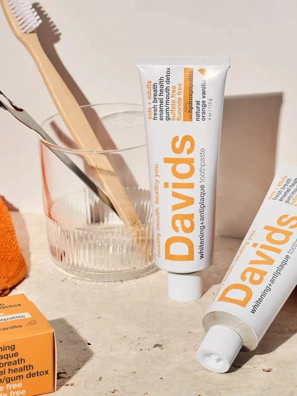 Davids Orange and Vanilla Toothpaste displayed with a toothbrush and glass