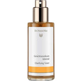 Dr Hauschka Clarifying Toner 100ml comes in a clear bottle with a gold spray pump and amber liquid inside. The white label features orange accents and text in German and English. Ideal for oily or blemished skin.
