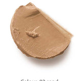 A swipe of Dr Hauschka Coverstick 2g in shade 02 sand is displayed on a white background, highlighting its creamy beige formula ideal for naturally concealing blemishes.
