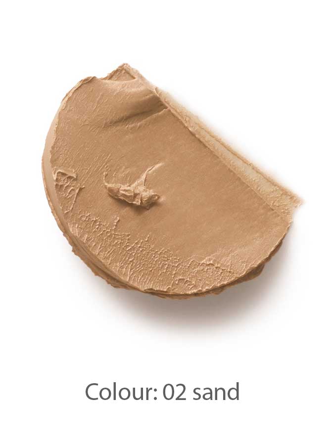 A swipe of Dr Hauschka Coverstick 2g in shade 02 sand is displayed on a white background, highlighting its creamy beige formula ideal for naturally concealing blemishes.