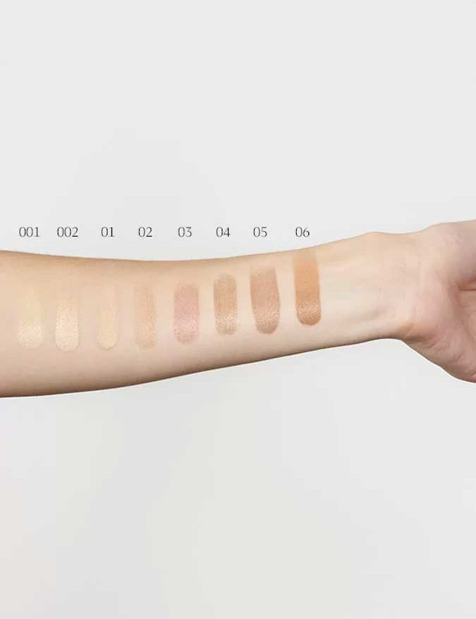 Six swatches of Dr Hauschka Foundation 30ml, labeled 001 to 006 from light to medium-dark, are shown on an inner forearm against a white background for flawless, natural foundation inspiration.