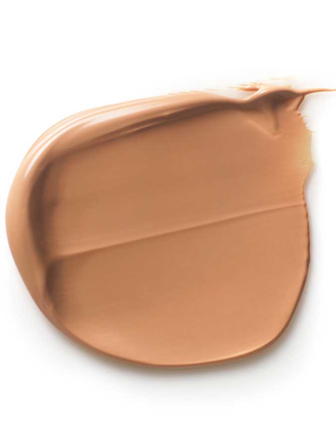 A smooth swipe of Dr Hauschka Tinted Day Cream 30ml on a white background reveals its creamy texture and even application, giving a light brown tint for a natural glow.
