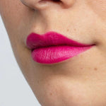 Close-up of a person’s lower face with smooth, light skin and bright pink “Dragon Fruit Pink” Antipodes Moisture Boost Natural Lipstick 4g, enriched with avocado oil for nourishment and vibrant color.