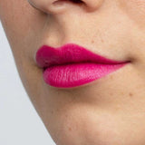 Close-up of a person’s lower face with smooth, light skin and bright pink “Dragon Fruit Pink” Antipodes Moisture Boost Natural Lipstick 4g, enriched with avocado oil for nourishment and vibrant color.