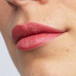 A close-up of lips wearing Antipodes Moisture Boost Natural Lipsticks 4g in matte dusky pink, with smooth skin visible. Infused with Avocado Oil for hydration. The text "Dusky Sound Pink" appears at the bottom of the image.
