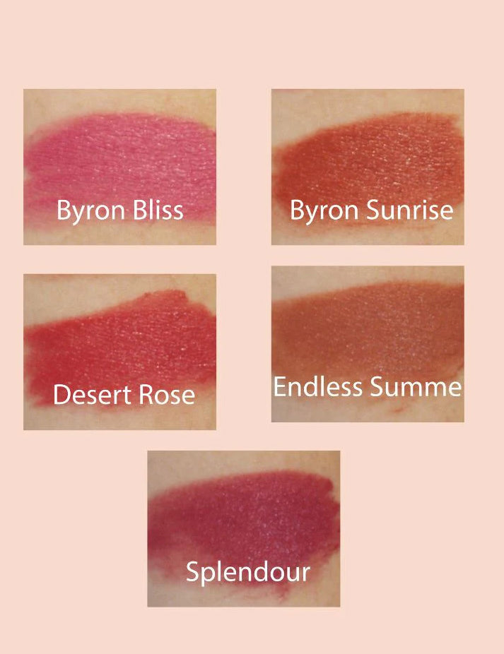 Five shades of Eco Minerals Eco Lipsticks 4g, Byron Bliss (pink), Byron Sunrise (peach), Desert Rose (warm pink), Endless Summer (brown), and Splendour (deep berry), are swatched on skin against a pale pink background.