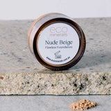 A small round container labeled Eco Minerals Flawless Matte Mineral Foundation 5g sits on a stone surface, with loose beige powder in front, offering a matte finish and natural SPF25 protection.