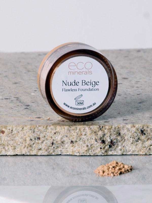 A small round container labeled Eco Minerals Flawless Matte Mineral Foundation 5g sits on a stone surface, with loose beige powder in front, offering a matte finish and natural SPF25 protection.