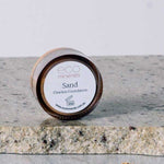 A 5g jar of Eco Minerals Flawless Matte Mineral Foundation rests on a stone surface, with some powder spilled beside it. The visible label shows the product name, website, and notes its natural SPF25 protection.