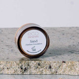 A 5g jar of Eco Minerals Flawless Matte Mineral Foundation rests on a stone surface, with some powder spilled beside it. The visible label shows the product name, website, and notes its natural SPF25 protection.