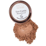 A 4g container of Eco Minerals Mineral Bronzer - Eco Exotic sits on a white background with some vegan, talc-free loose bronzer powder spilled beneath it.