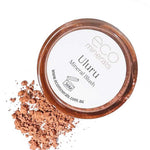 A circular container of Eco Minerals Mineral Blush - Uluru 4g sits with loose, peachy-pink vegan blush powder beside it. The lid features the brand and product name.