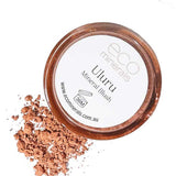 A circular container of Eco Minerals Mineral Blush - Uluru 4g sits with loose, peachy-pink vegan blush powder beside it. The lid features the brand and product name.