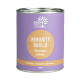 A cylindrical purple tin labeled Eden Healthfoods Immunity Shield 100g features "Boost your defence," "Protect. Rebuild. Restore.", certified organic, and Echinacea angustifolia for immune support on the front.
