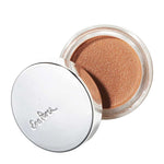 The Ere Perez Cacao Bronzing Pot - Sol 7.5g is a small round jar of vegan cream bronzer with a shimmery bronze hue and shiny silver lid embossed with cursive writing, partially opened to reveal the product for a natural glow.