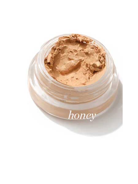 The Ere Perez Arnica All-Cover Pot 5g is a small glass jar of creamy, light tan concealer labeled "Honey" on a white background, offering buildable coverage.