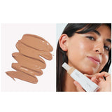 On the left: a swatch of Ere Perez Oat Milk Foundation 30ml in medium neutral. On the right: a woman with medium skin tone applies foundation in shade Maple to her cheek while holding the bottle. Text: Maple | Medium coverage.
