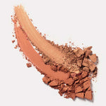 A close-up of two crushed powders—light beige and warm brown Ere Perez Rice Powder Bronzer - Tulum 9g—smeared diagonally on white, highlighting the natural, vegan bronzer’s textured blend and fragments.