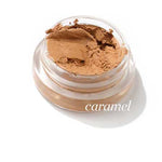 The Ere Perez Arnica All-Cover Pot 5g is a small, clear jar of caramel-colored cream concealer labeled "caramel," offering buildable coverage and displayed against a white background.