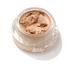 A small clear jar of Ere Perez Arnica All-Cover Pot 5g in "Latte," a creamy light beige concealer with buildable coverage, is shown on a white background.