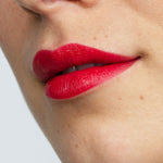 Model wearing Antipodes Moisture Boost Natural Lipstick in Forest Berry Red