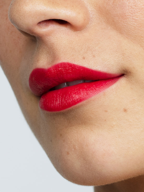Model wearing Antipodes Moisture Boost Natural Lipstick in Forest Berry Red