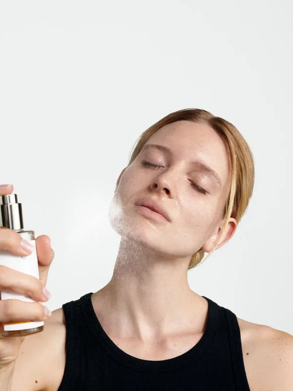 Model misting Dr Hauschka toner on her face