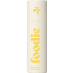 The Foodie Pineapple Crush Kiss Lip Balm 10g comes in a cream-colored cylinder with bold yellow "foodie" text and a fun logo on the cap, offering a playful pineapple-flavored lip balm perfect for teens.