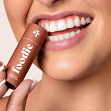 Model applying Foodie Chocolate Crunch Kiss Lip Balm