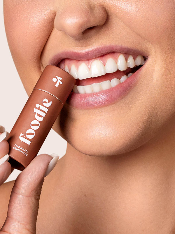Model applying Foodie Chocolate Crunch Kiss Lip Balm