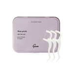 Purple floss pick container with white floss picks on a white background