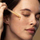 Model applying Antipodes Glow Vitamin C Brightening Serum with a dropper